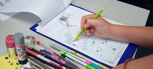 School Child Drawing Cartoons in Workshop